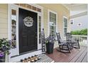Charming front porch with a welcoming door, rocking chairs, and decorative plants at 113 Market Cross Ct, Holly Springs, NC 27540