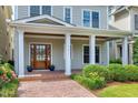 Inviting front porch with brick walkway, decorative plants, and a lovely wooden front door at 1217 Chalk Maple Dr, Cary, NC 27519