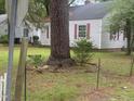 Home with vinyl siding and red shutters, framed by mature trees and greenery at 1256 Planters St, Rocky Mount, NC 27801