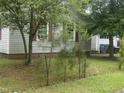 Property featuring mature trees, vinyl siding, and red window shutters at 1256 Planters St, Rocky Mount, NC 27801