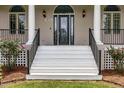 Inviting front entry with white steps, decorative door, and classic black railings at 1672 Wheeler Dr, Angier, NC 27501