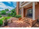 Inviting front entrance with brick steps, classic columns, and a beautifully adorned front door at 1831 Middlebrook Dr, Raleigh, NC 27615