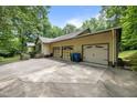 Spacious three-car garage with an expansive concrete driveway and mature trees at 2382 Council Rd, Graham, NC 27253