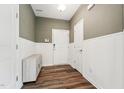Welcoming entryway featuring wainscoting, wood floors, a storage bench, and a white front door at 241 White Oak Ridge Dr, Garner, NC 27529