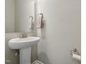 Bright powder room featuring a pedestal sink, decorative mirror, and neutral color scheme at 241 White Oak Ridge Dr, Garner, NC 27529