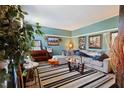 Comfortable living room featuring a gray sofa, striped rug, piano, and light blue walls at 3013 Brassfield Dr, Rocky Mount, NC 27803