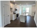 Open-concept kitchen featuring modern appliances, a center island, and white cabinets at 3103 White Blossom Ct, Raleigh, NC 27610