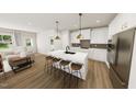 Bright, modern kitchen with white cabinets, quartz countertops, and a large island with seating at 320 Beacon Dr, Pittsboro, NC 27312