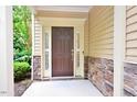 Front door featuring sidelights, neutral siding and brick accents at 321 Westgrove Ct, Durham, NC 27703