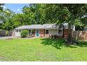 Beautiful ranch-style home with vibrant lawn, mature trees, teal front door, and charming landscaping at 3216 Idlewood Village Dr, Raleigh, NC 27610