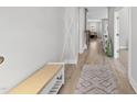 Bright foyer with hardwood floors, rug, bench, coat rack, and ample natural light at 34 Millennium Dr, Pittsboro, NC 27312