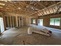 A spacious room with framing and rough concrete floors; this home is ready for customization at 4024 N Nc 581 Hwy, Kenly, NC 27542