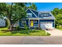 Charming two-story blue home with a bright yellow front door and well-manicured lawn at 405 Culvert St, Apex, NC 27502