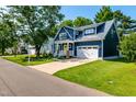 Charming blue two-story home featuring a yellow front door, manicured lawn and white trim at 405 Culvert St, Apex, NC 27502