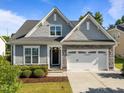 Charming single Gathering home boasts manicured lawn, stone accents, and two car garage in daytime at 427 Cedar Pond Ct, Knightdale, NC 27545