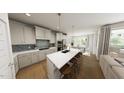 Modern kitchen with white cabinetry, stainless steel appliances, an island with seating, and eat-in dining area at 528 Folk Song Way, Wendell, NC 27591
