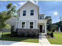 Beautiful two-story home with a stone facade, manicured lawn, and welcoming entrance at 5649 Cayden Cove Dr, Wendell, NC 27591