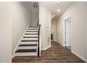 Bright entryway featuring a staircase with dark wood handrail and luxury vinyl flooring, leading to the upper level at 6107 Kayton St, Raleigh, NC 27616
