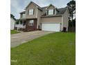 Attractive two-story home featuring neutral siding, a spacious driveway, and an attached two-car garage at 642 Pinevalley Ln, Sanford, NC 27332
