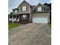 Beautiful tan two-story home with a spacious driveway, 2 car garage, and brick facade at 642 Pinevalley Ln, Sanford, NC 27332