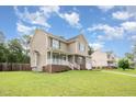 Side view of a cozy two-story home with a porch, lush lawn, and tree lined streets at 642 Pinevalley Ln, Sanford, NC 27332