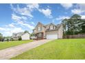 View of a charming two-story home with an attached garage and landscaped front yard at 642 Pinevalley Ln, Sanford, NC 27332