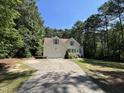 Beautiful home with an attached garage and a long driveway nestled amongst mature trees at 65 Shorrey Pl, Youngsville, NC 27596