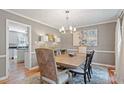 Elegant dining room featuring a modern chandelier, hardwood floors, a stylish rug, and gray walls at 7209 St Ledger Dr, Raleigh, NC 27613