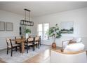Bright dining room with a stylish light fixture, wood table, and neutral decor at 8701 Erinsbrook Dr, Raleigh, NC 27617