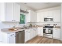 Well-lit kitchen with stainless steel appliances and white cabinetry at 8701 Erinsbrook Dr, Raleigh, NC 27617