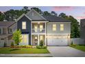 Charming two-story home features a welcoming front porch, two car garage, and beautifully landscaped yard at 9120 Dupree Meadow Dr, Angier, NC 27501