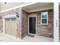 Charming townhome featuring an attached garage with stylish brick and stone exterior at 103 Ransomwood Dr, Apex, NC 27539