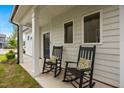 Inviting front porch featuring two rocking chairs and decorative pillows at 1038 Felman Rd, Durham, NC 27703