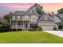 Charming two-story home featuring a spacious front yard, beautiful landscaping, and a two-car garage at 105 Acorn Ridge Ln, Holly Springs, NC 27540