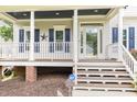 Charming front porch featuring white columns, blue shutters, and a welcoming front entrance at 105 Acorn Ridge Ln, Holly Springs, NC 27540
