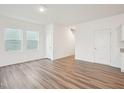Bright open living space featuring hardwood floors, white walls and a hallway with staircase access at 1212 Solace Way, Rolesville, NC 27571