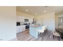 Bright kitchen featuring white cabinets, stainless appliances, granite countertops and an island with bar stool seating at 1213 Solace Way, Rolesville, NC 27571