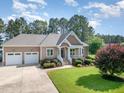 Charming exterior showcases a tan home with a two-car garage and well-manicured front lawn at 142 Crestline Dr, Selma, NC 27576
