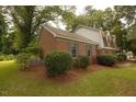 Side view of a charming brick home with well-maintained landscaping and blue shutters at 1513 Western Ave, Rocky Mount, NC 27804