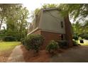 Rear view of brick home with brick chimney, trim, and surrounding trees at 1513 Western Ave, Rocky Mount, NC 27804