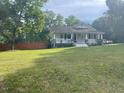 Cozy one-story home with a covered front porch surrounded by a lush lawn at 2037 Swepsonville Rd, Graham, NC 27253