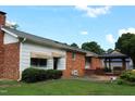 Spacious backyard with a brick patio, gazebo, and mature trees, perfect for outdoor entertaining at 2071 Meadow Ln, Graham, NC 27253
