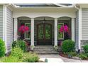 Inviting front porch with stone accents and elegant flower arrangements at 2121 Vecchio Ln, Apex, NC 27502