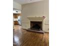 Cozy living room with a brick fireplace and hardwood flooring at 2237 Keith Hills Rd, Lillington, NC 27546