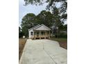 Inviting single-story home featuring a cozy front porch and a spacious new driveway at 2301 Pinecroft Dr, Burlington, NC 27217