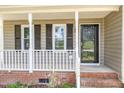 Home with brick-lined porch and black door has an inviting space to relax and greet guests at 2324 Dahlgreen Rd, Raleigh, NC 27615