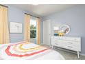 Charming bedroom with two windows, a white dresser, decor, and rainbow-themed bedding at 234 Macon Lake Drive # 39, Apex, NC 27523