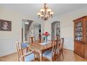 Elegant dining room with wood table, chandelier, and view of the staircase, great for hosting gatherings at 3104 Whitehart Ln, Apex, NC 27539