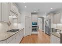 Bright kitchen with white cabinets, stainless steel appliances, and hardwood floors, perfect for culinary enthusiasts at 3104 Whitehart Ln, Apex, NC 27539