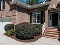 Charming brick home entrance with well-maintained landscaping and black shutters at 3709 Andoversford Ct, Wake Forest, NC 27587